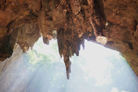 Sun rays in cave and beautiful stalactites formation in Thailand.           