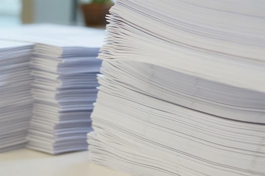 Stack of white papers sheet was organized  on office background.                                