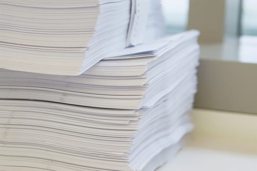 Stack of white papers sheet was organized  on office background.                                