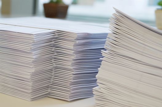 Stack of white papers sheet was organized  on office background.                               