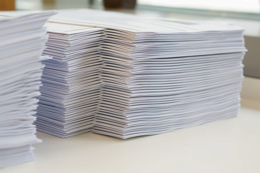 Stack of white papers sheet was organized  on office background.                                