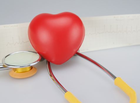 Medical stethoscope with red heart and electrocardiogram  on white background.