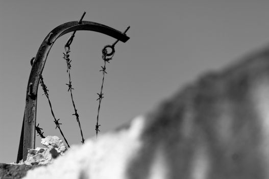 Barbed wire over concrete wall black and white