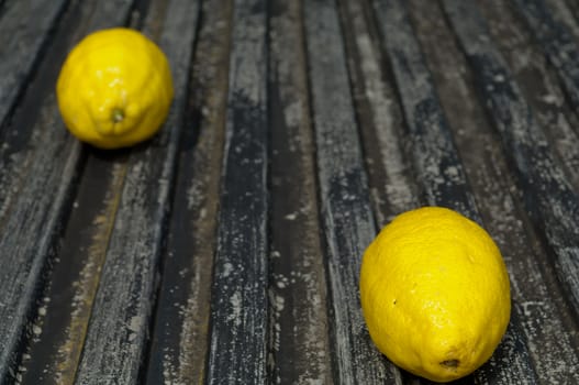 Lemon and lime arrangement on old black textured metal surface