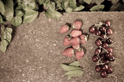 Delicious ripe strawberry and cherry on grey stone flat lay Healthy fruit eating Top view