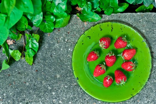 Delicious ripe strawberry  on green plate on grey stone flat lay Healthy fruit eating Top view