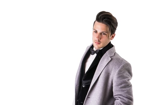 Young businessman confidently posing and looking at camera, wearing suit isolated on white background