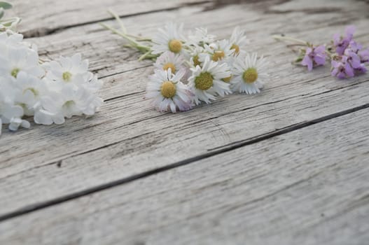 Small bunches of flowers on wooden background copy space textured surface