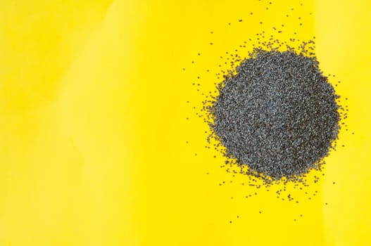 Poppy seeds isolated on yellow background poppy seed, pile of poppy seeds