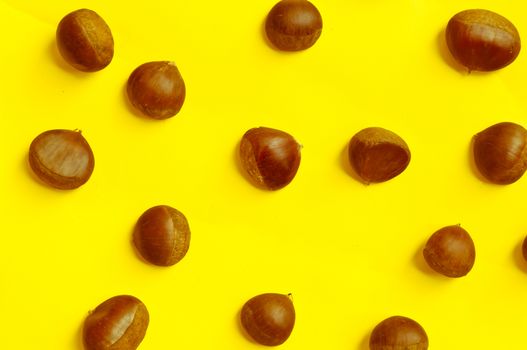 Chestnuts pattern on yellow background, top view, chestnut, castanea