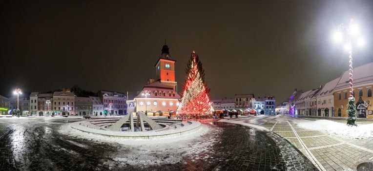 BRASOV, ROMANIA - 15 DECEMBER 2016: Brasov Council House panoramic night view with Christmas Tree decorated and traditional winter market in the old town center, Romania