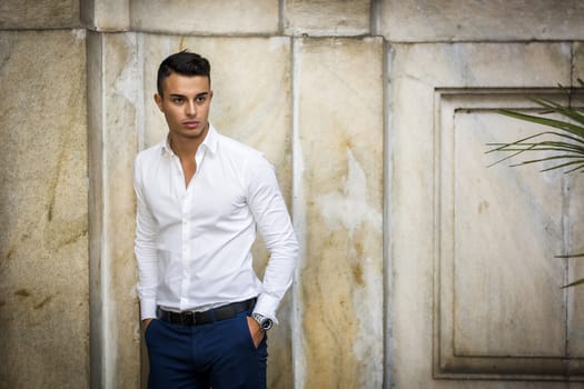 Elegant attractive young man outdoor wearing business suit, in European city