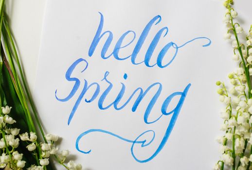 frame lily of the Valley and text Hello spring. Calligraphy lettering.