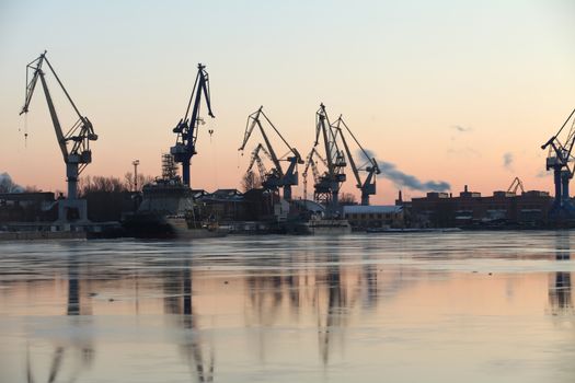 Silhouettes of of portal cranes reflection on the water