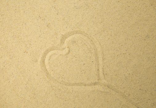 Heart drawn in the sand. Beach background. Top view