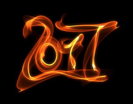 Happy new year 2017 isolated numbers lettering written with fire flame or smoke on black background.