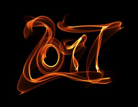 Happy new year 2017 isolated numbers lettering written with fire flame or smoke on black background.