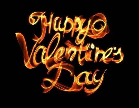 Happy Valentines day isolated words lettering written with fire flame or smoke on black background.