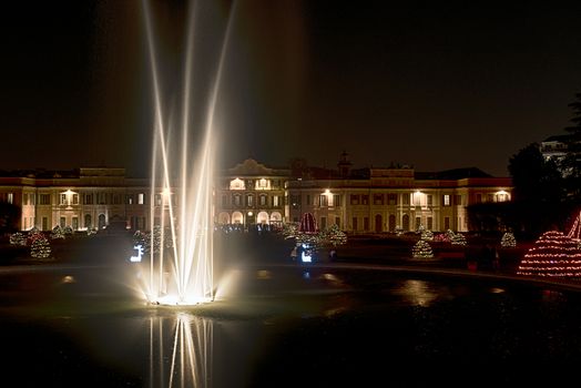 Fountain in the foreground and Christmas lights in the public gardens of Varese