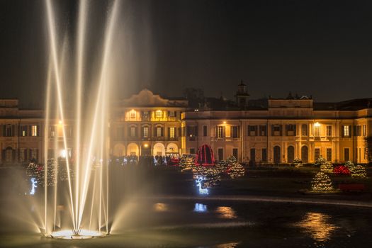 Fountain in the foreground and Christmas lights in the public gardens of Varese