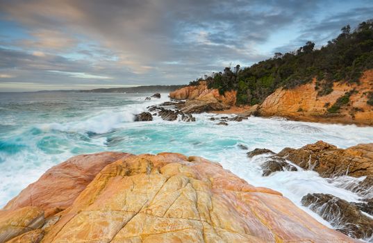 Bermagui coastline, with beautiful peach and apricot colours in the sandstone and aqua blue waters