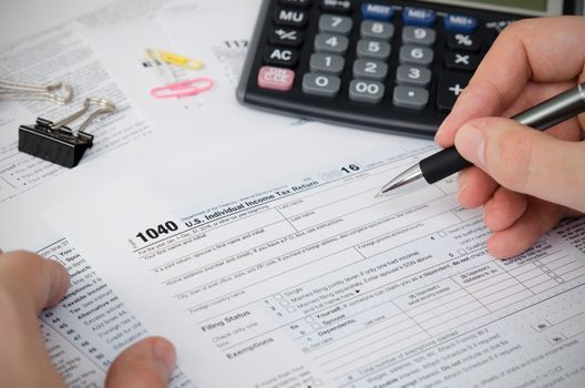 Man filling US tax form. tax form us business income office hand fill concept