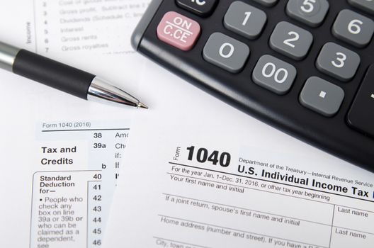 US tax form 1040 with pen and calculator. tax form law document usa white mathematics business concept