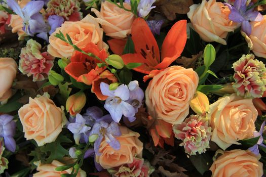 Lilies and roses in a various shades of orange in a bridal arrangement