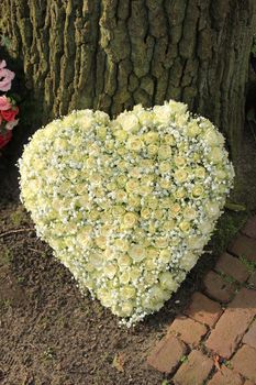 A heart shaped funeral flower arrangement, white roses
