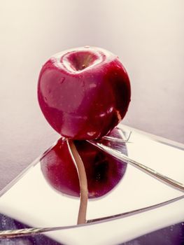 Red apple on cracked broken mirror reflecting