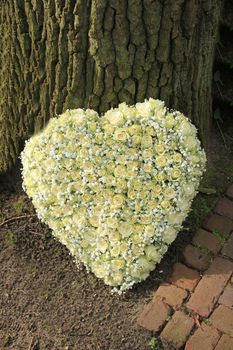 A heart shaped funeral flower arrangement, white roses