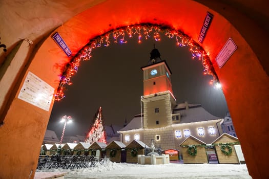 Brasov Council House night view decorated for Christmas and traditional winter market in the old town center, Romania