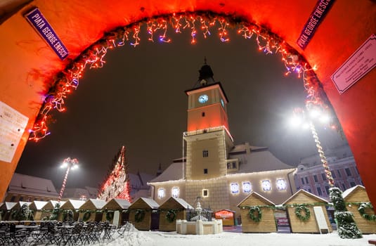 Brasov Council House night view decorated for Christmas and traditional winter market in the old town center, Romania