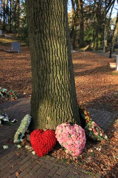 Heart shaped funeral flower arrangements near a tree