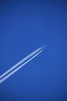 Contrails of a big airplane in a clear blue sky