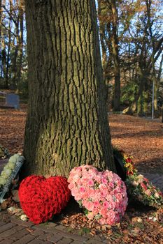 Heart shaped funeral flower arrangements near a tree