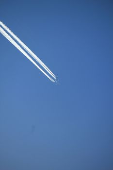 Contrails of a big airplane in a clear blue sky