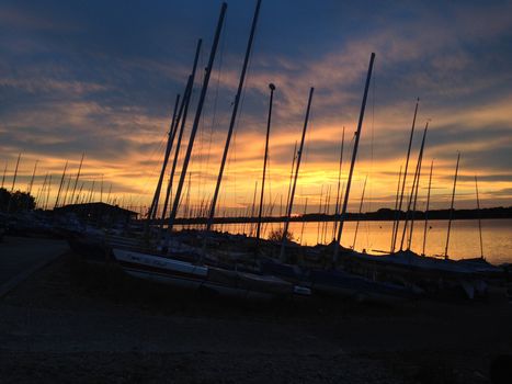 Masts of sailing boats against a moody sky