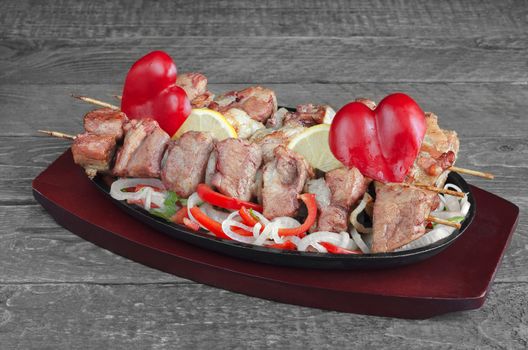 Grilled pork with lemon, a salad of sweet peppers and onions and decorations in the shape of a heart.