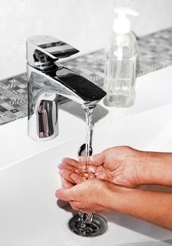 woman washing hands in sink, close up view