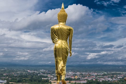 Buddha statue public landmark at Wat Phra that Kao Noi with dramaric clouds, Nan, Thailand