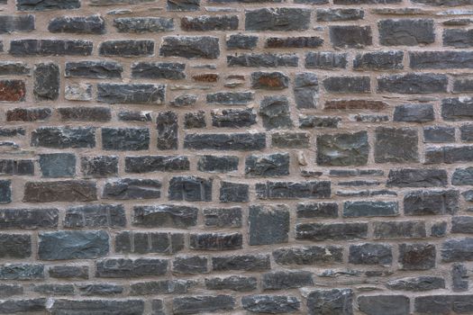 Background, old broken stone wall with relief texture and shadows.