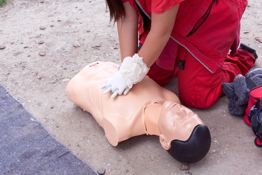 Female instructor showing cardiopulmonary resuscitation - CPR on training doll. First aid training.