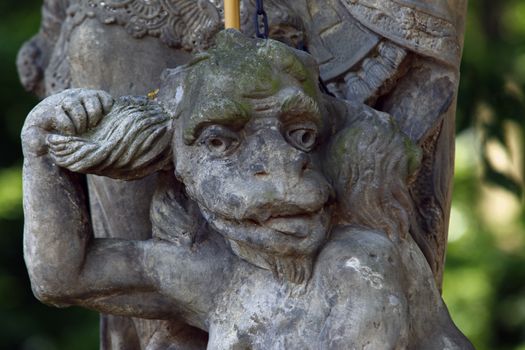 Baroque statue on the crossroad - Saint Procopius with bound devil.
Saint Procopius of Sazava (end of the 10th century Chotoun - March 25, 1053, Sazava) was originally a secular priest, later a hermit, co-founder and first abbot of the monastery Sazava. He was canonized in 1204. 
His main attribute is bound devil, which is at his feet or on which he stands.
Czech republic.