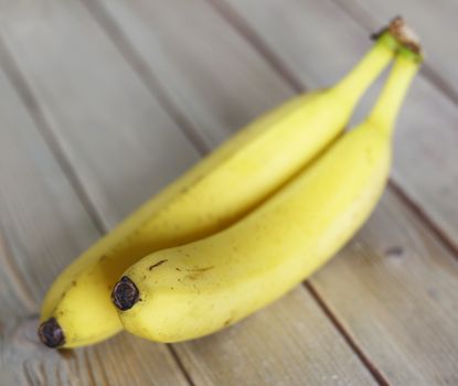 Ripe bananas on a rustic wooden tabletop in shallow depth of field - natural source of magnesium