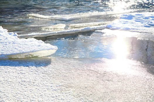 Cracked ice slabs in a river with snow