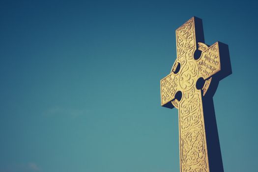 Celtic Cross Stone Gravestone Against Blue Sky With Copy Space