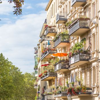Traditional European residential house with balconys with colorful flowers and flowerpots. Kreuzberg neighborhood, Berlin, Germany,