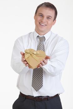 Young man with a heart shaped box in his hand on a white background