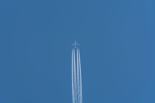 Aircraft flying at high altitude contrails against a dark blue sky.
